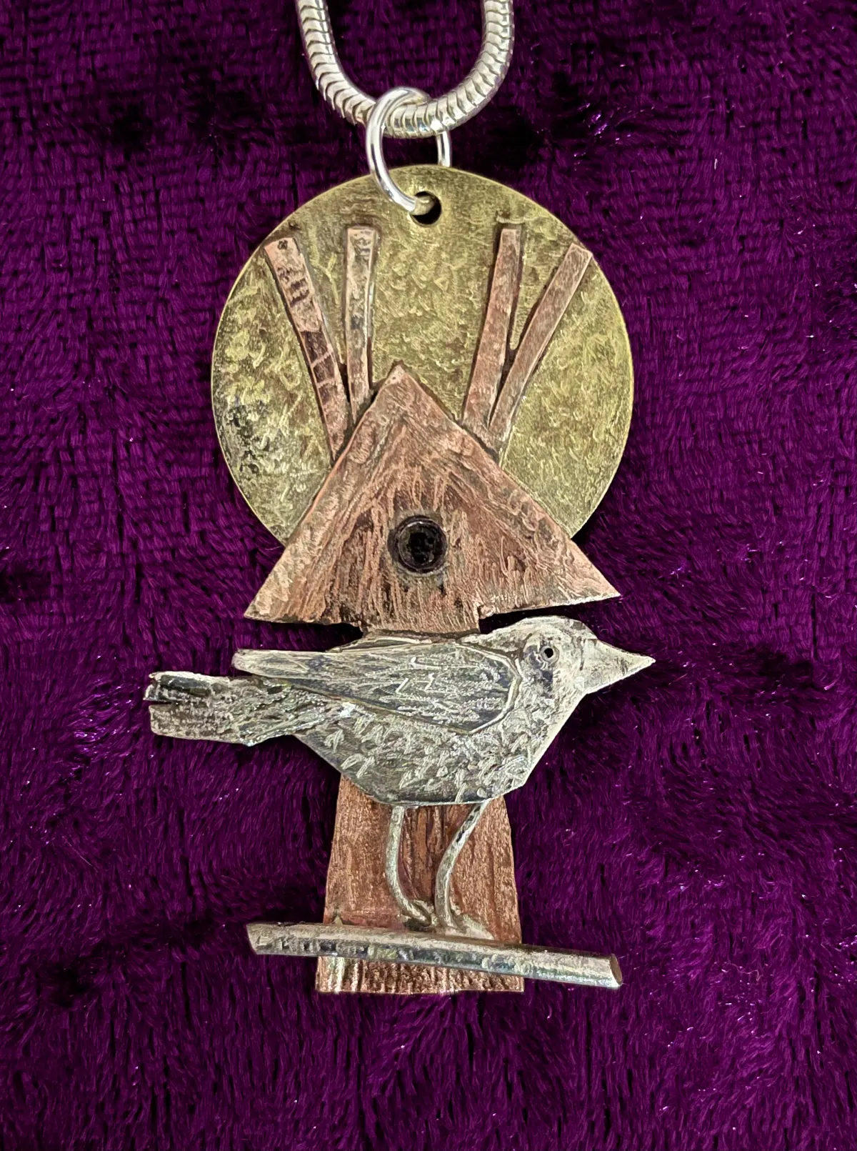 Silver bird on copper bird house
