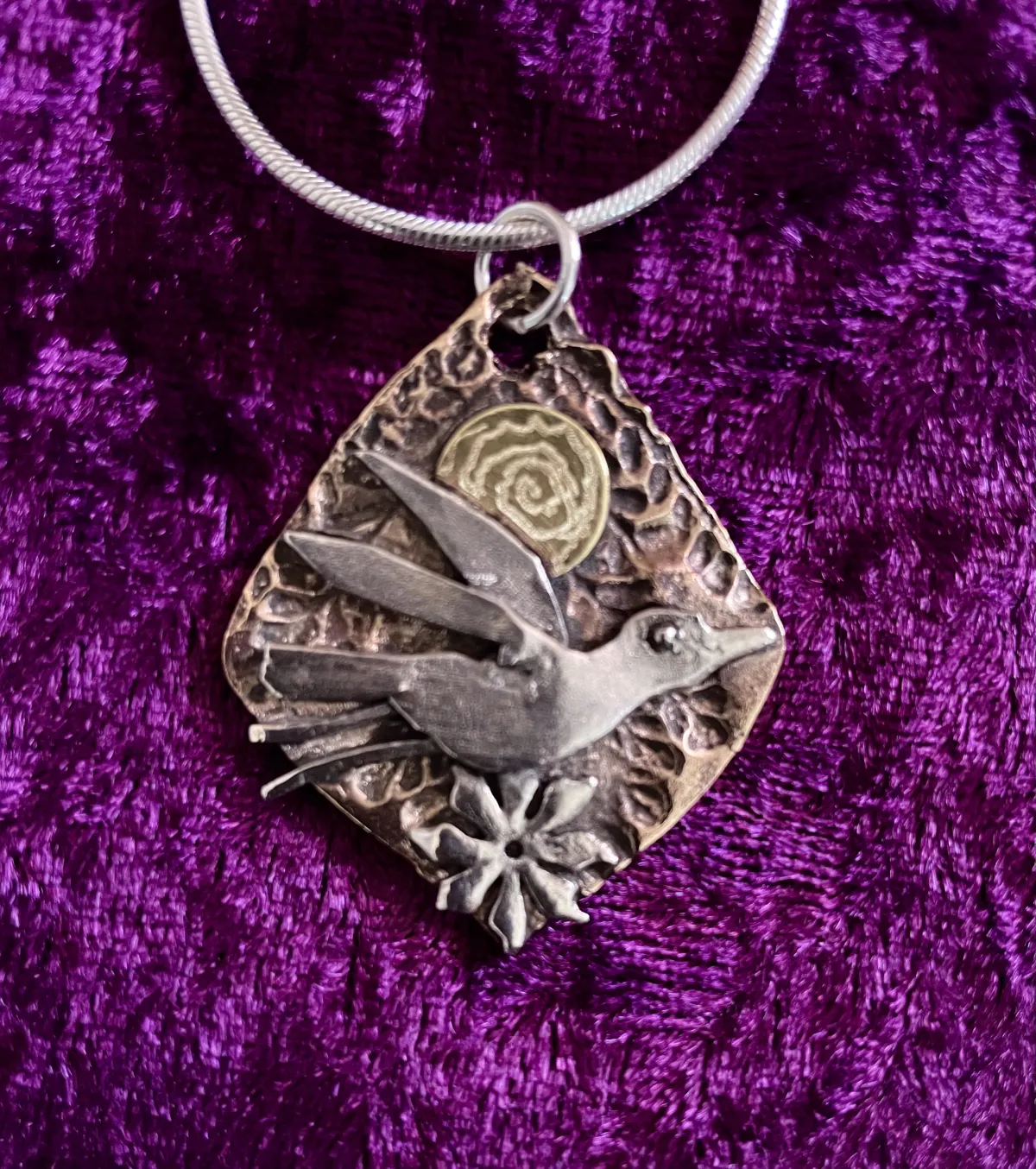 Silver bird on bronze pendant