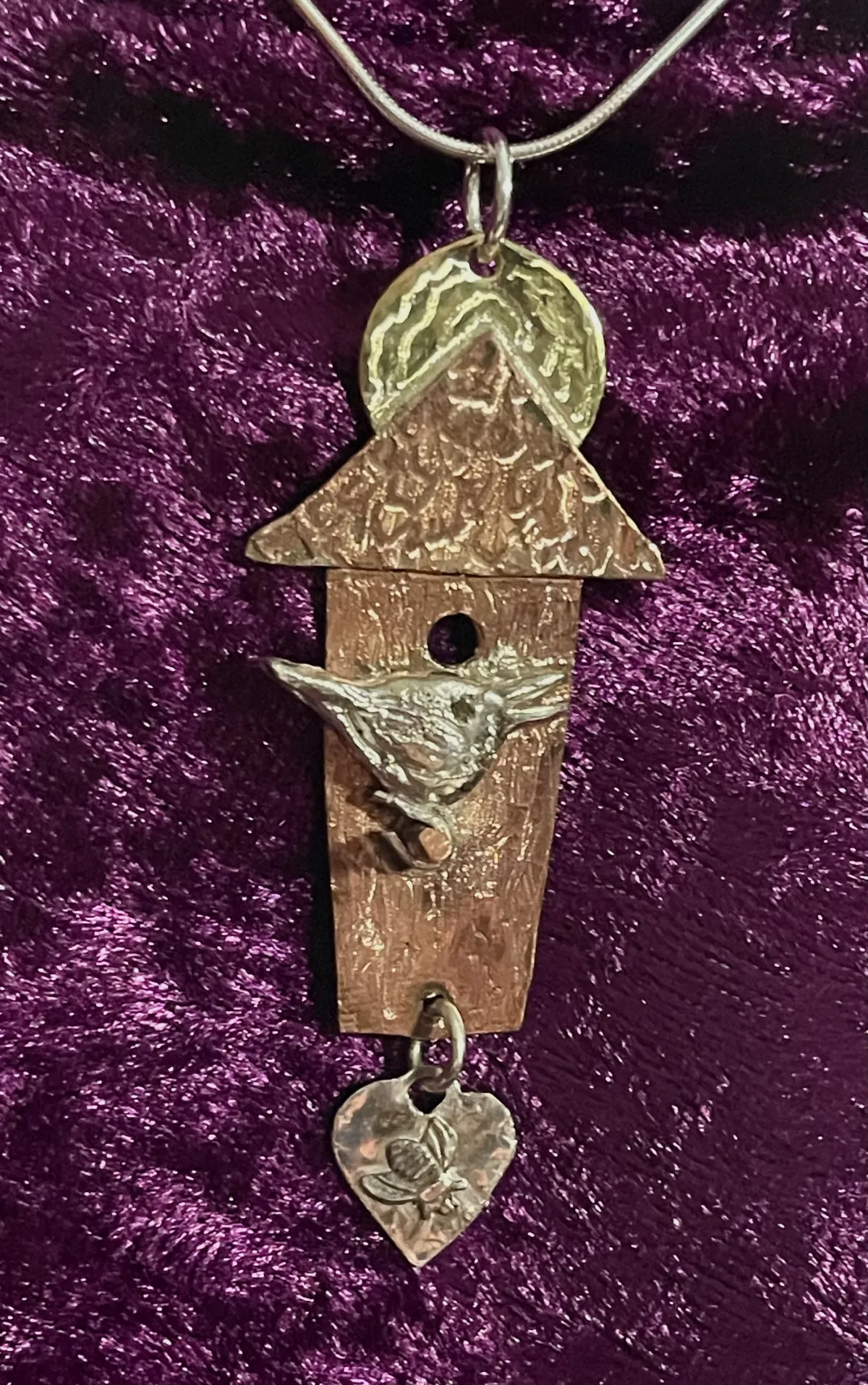Silver bird on copper birdhouse